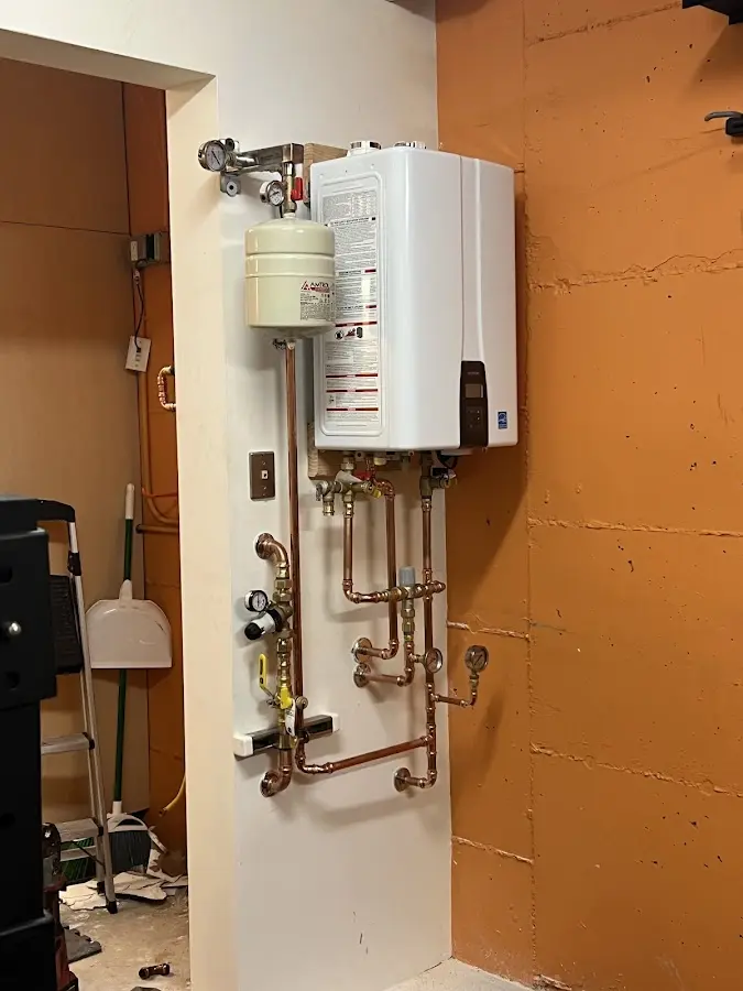 Plumbing technician inspecting water heater connections in Marathon